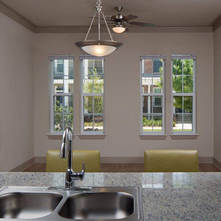 Interior view of kitchen and living area at Heritage Senior Residences at Columbia Parc - New Orleans, LA