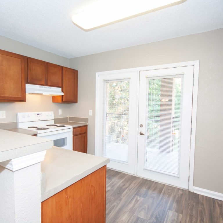 Kitchen with french exit doors to patio at Park Commons Apartments Community - Senior Apartments in Atlanta, GA