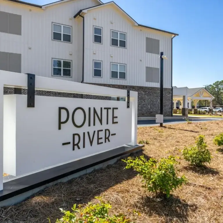 view of sign and building elevation on a sunny day at Pointe River apartments in Albany GA