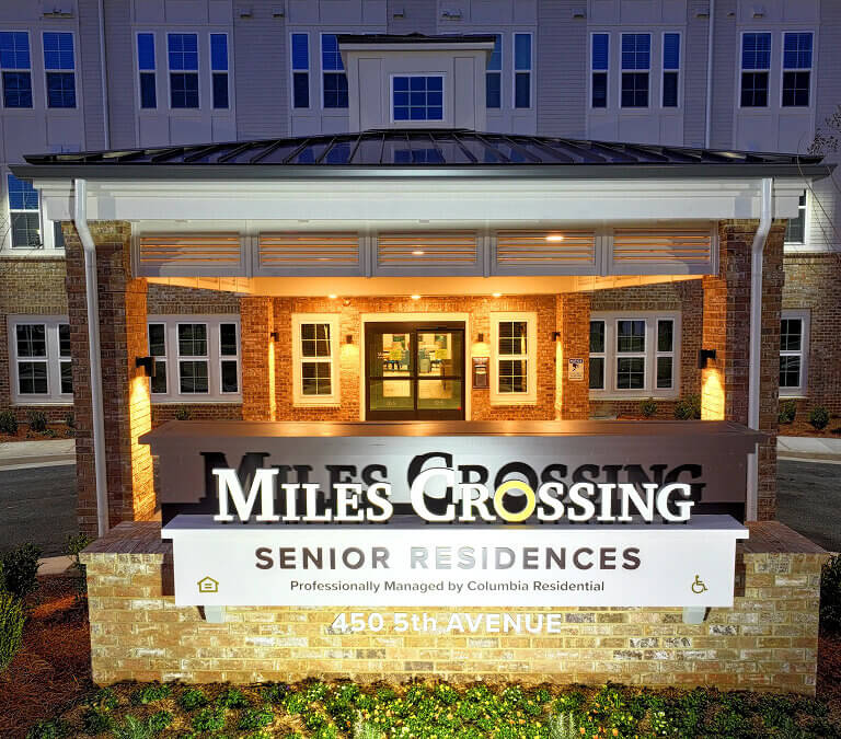 Entrance sign at Miles Crossing Senior Residences in Columbus, GA at night