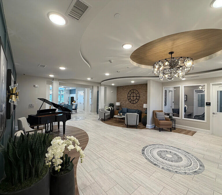Lobby and common area with seating and piano at Miles Crossing Senior Residences