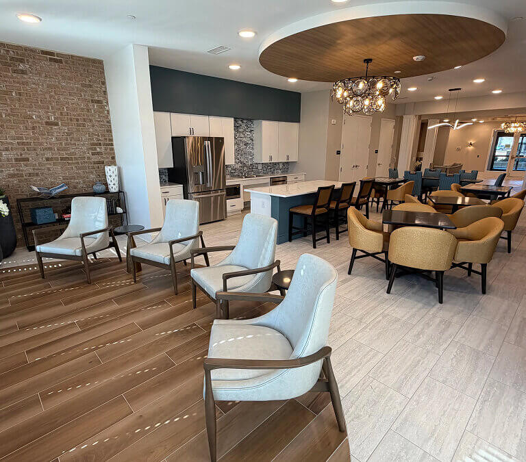 Apartment clubhouse with kitchen, seating area, and modern interior design