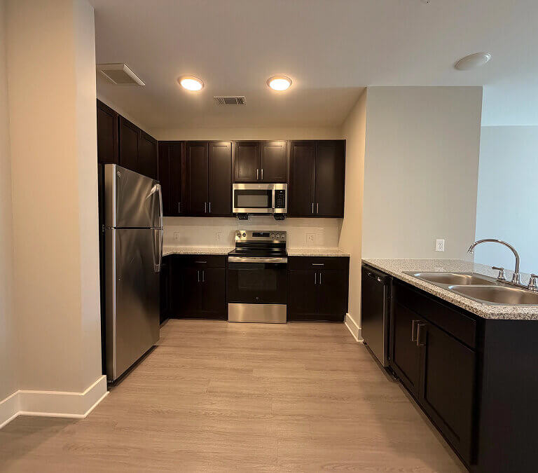 Apartment kitchen with stainless steel appliances and dark cabinets