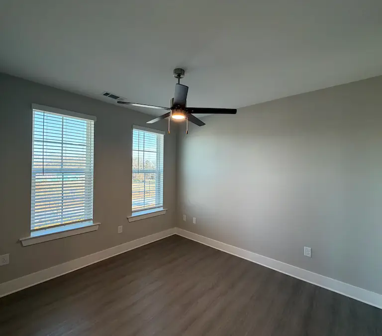 Secondary apartment bedroom with natural light and ceiling fan